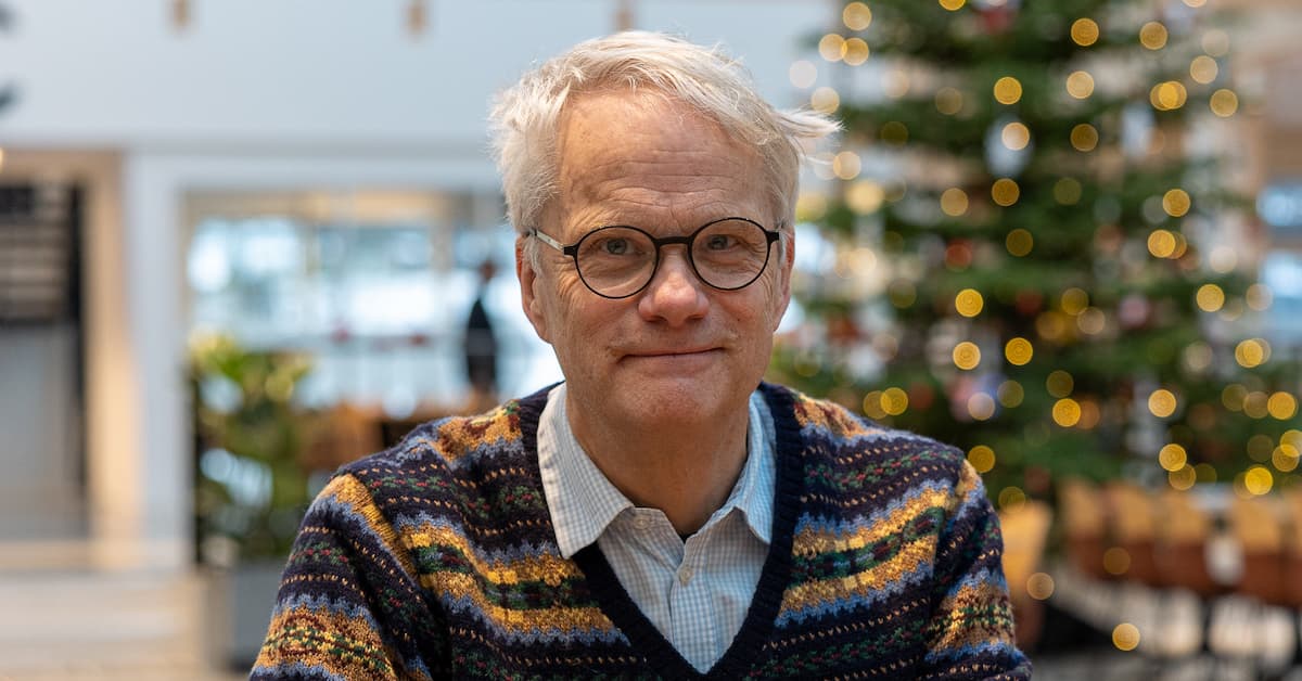 johan Smilende mann med juletre i bakgrunnen