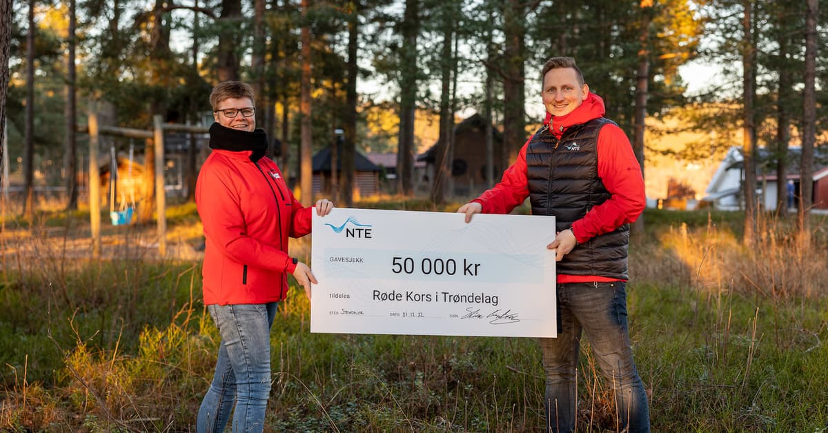 julegaver røde kors En mann og en kvinne holder en sjekk på 50 000 kroner mellom seg