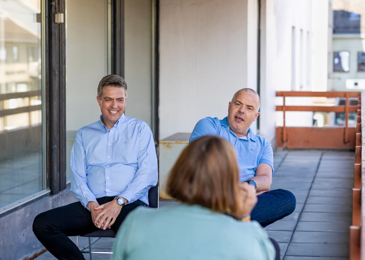To karer og en journalist To menn i samtale med en kvinne du ser bakhodet på