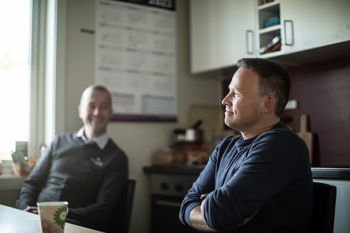 Tore Forbord i Alu Rehab To smilende menn i samtale ved et kjøkkenbord