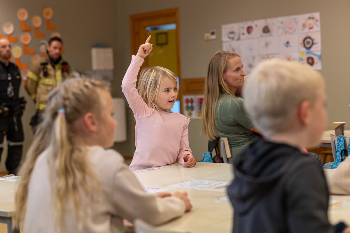 Jente fra Hovin skole Jente rekker opp hånda i klasserommet