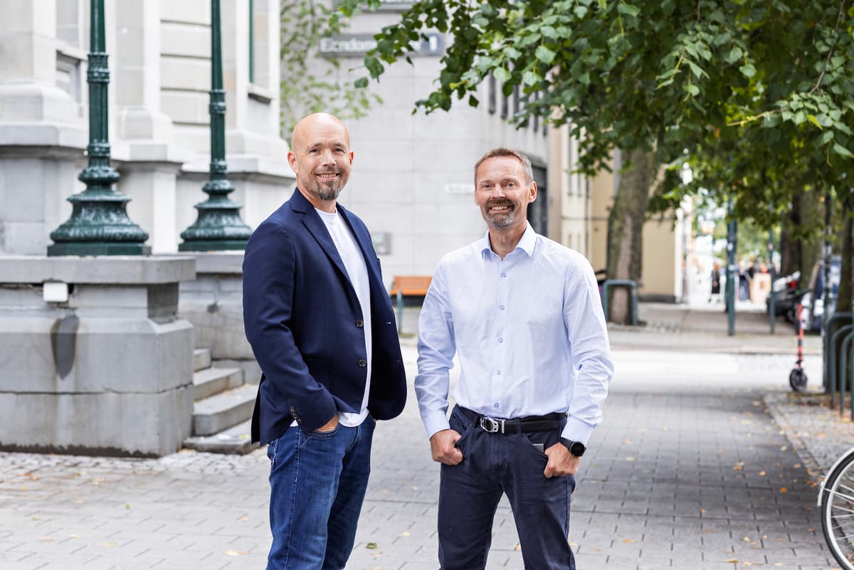Stian og Pål To smilende menn står i bybildet i Trondheim