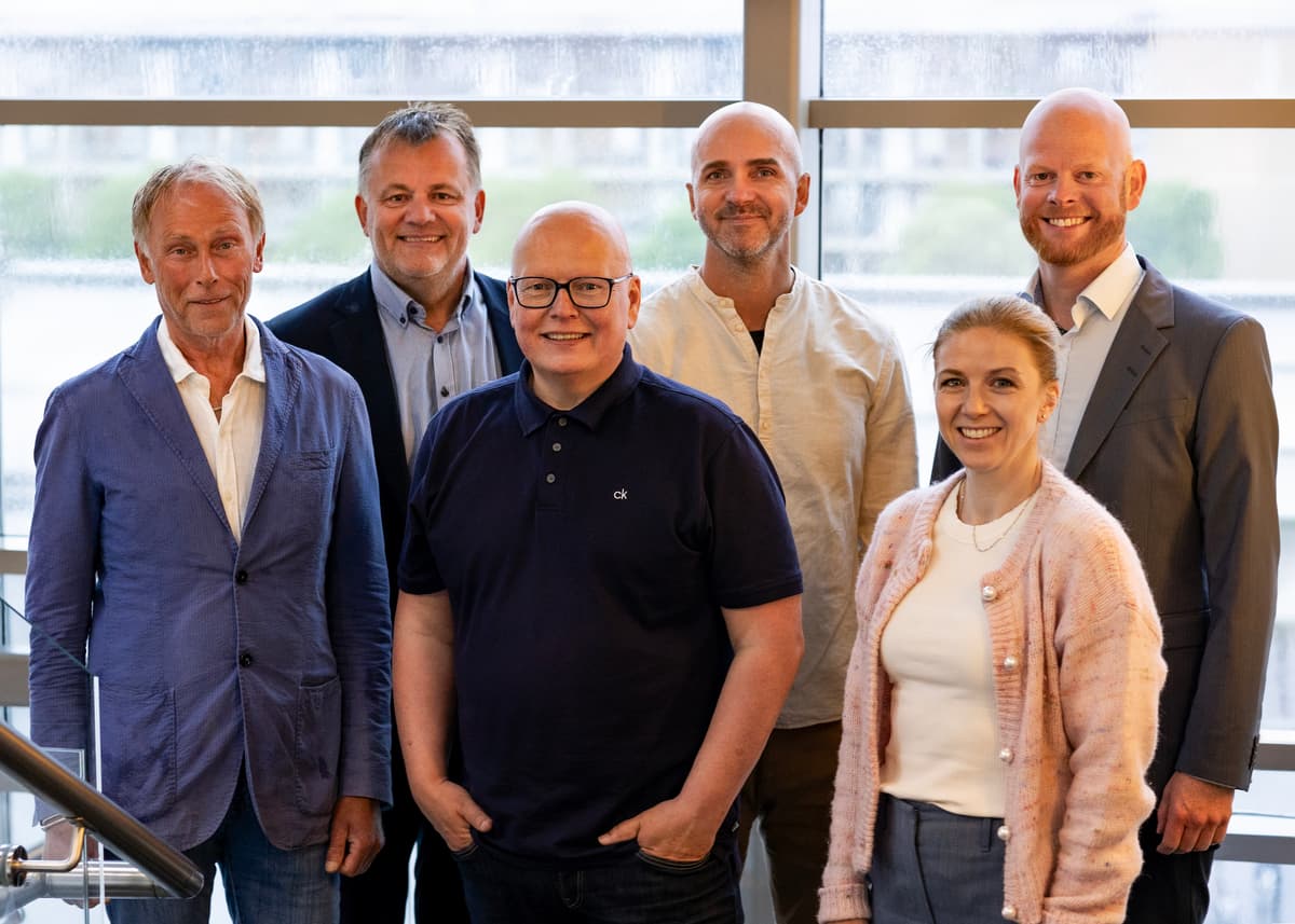 Fem menn og en kvinne smiler til kameraet Fem menn og en kvinne smiler til kameraet