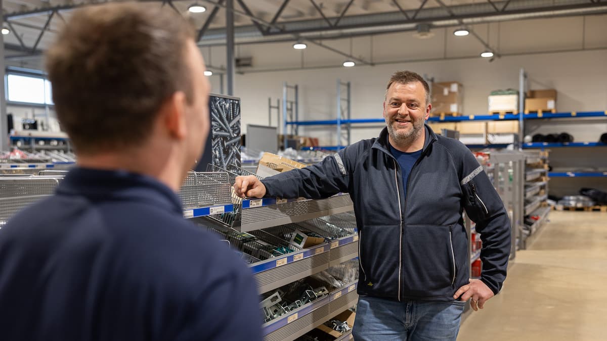 tom aunan Smilende mann i samtale med en mann vi bare ser ryggen på