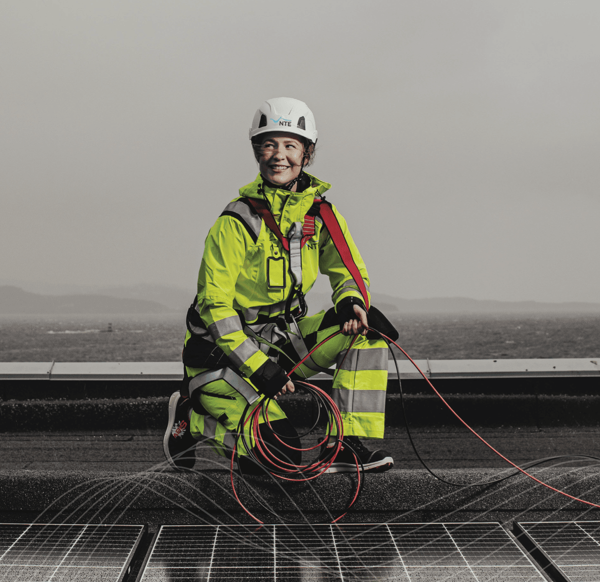 Kvinnelig montør installerer solceller på taket. Kvinnelig montør installerer solceller på taket.