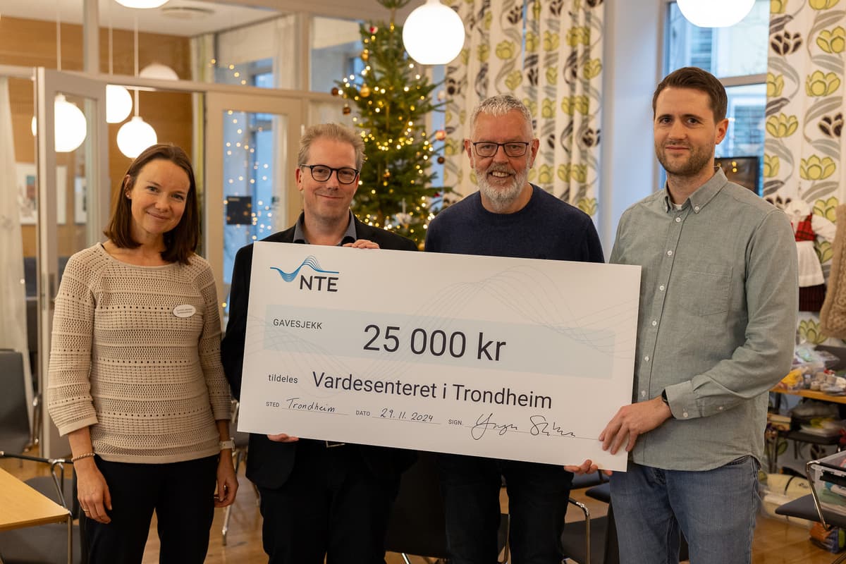 Utdeling av julegavesjekk på Vardesenteret En kvinne og tre menn står foran et juletre og holder opp en sjekk på 25 000 kroner til Vardesenteret i Trondheim