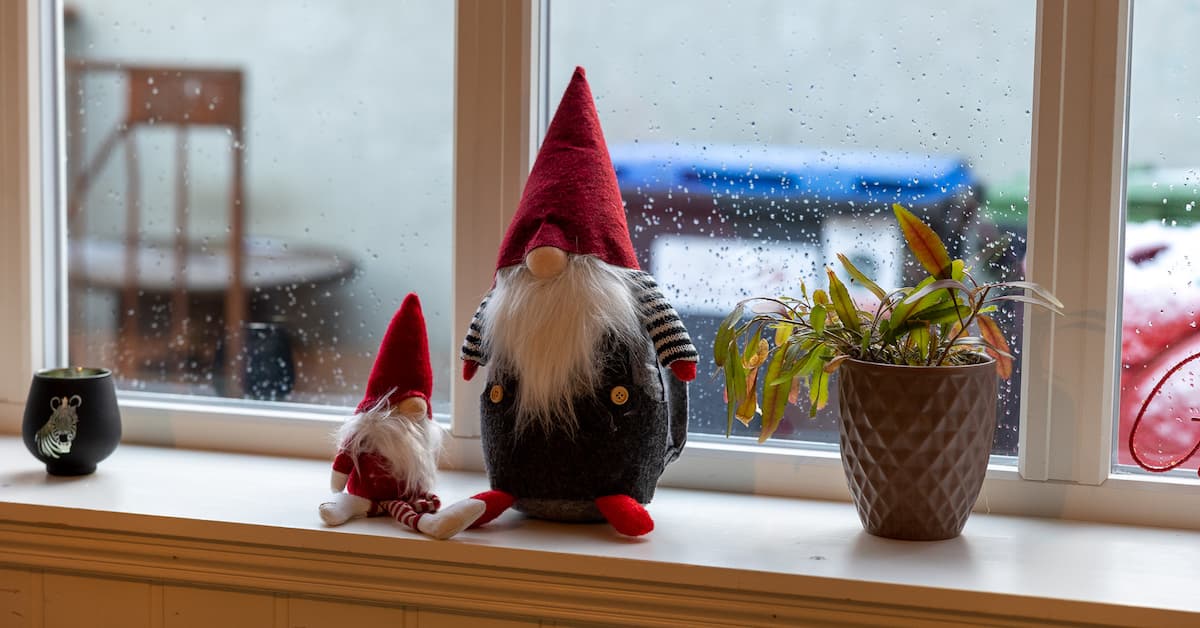 julepynt To nisser og en plante i en vinduskarm