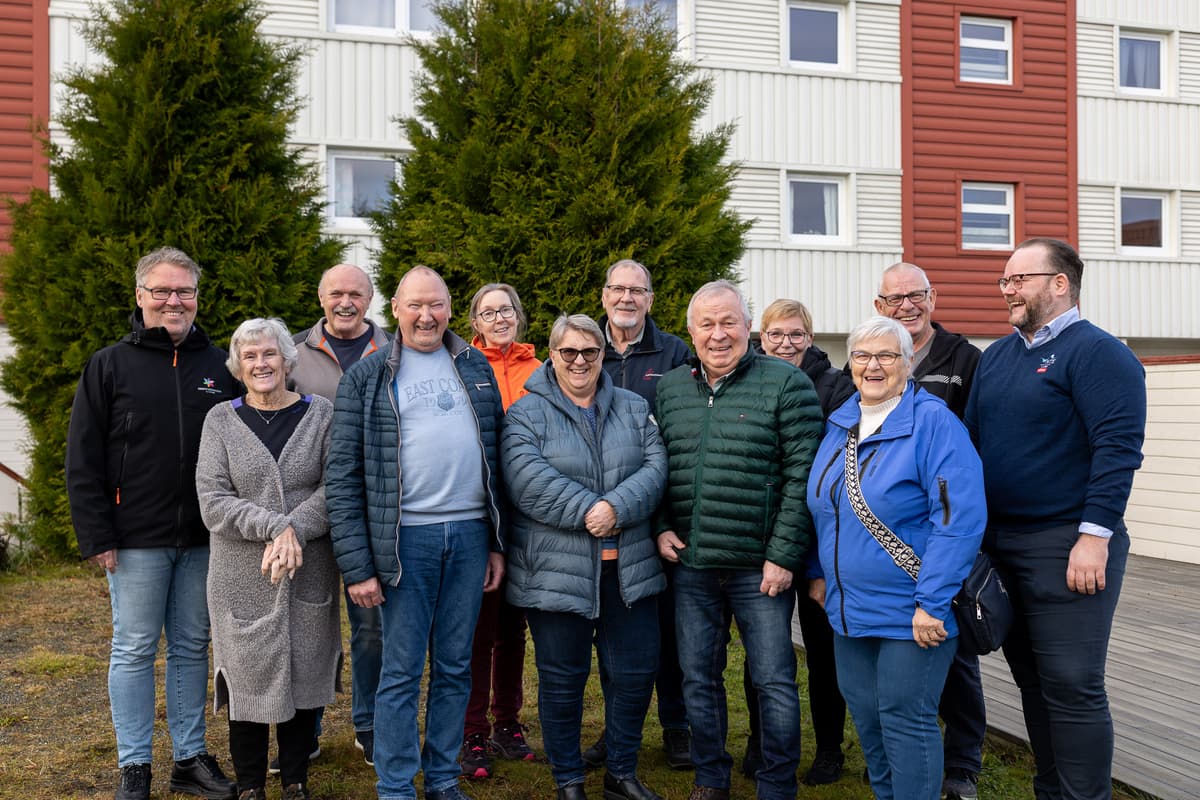 Beboerne i Vilhelmsmyr borettslag 12 blide mennesker utenfor en blokk