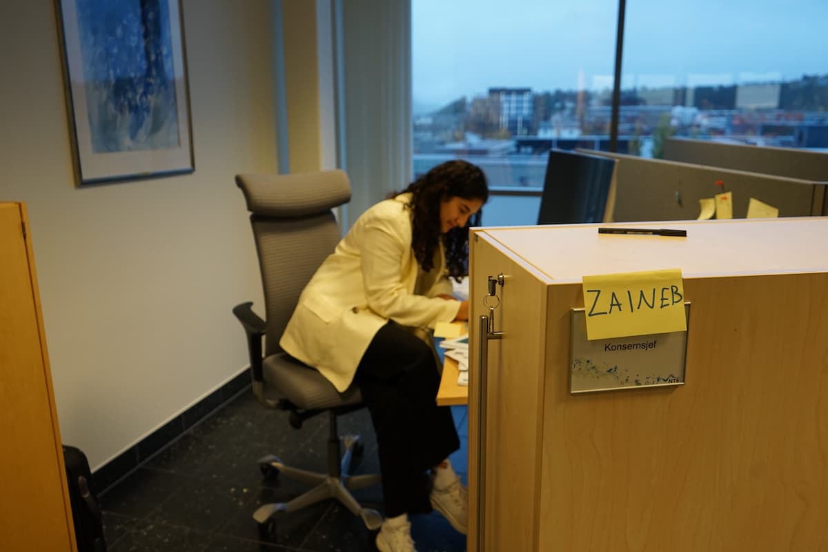 Zaineb konsernsjef Kvinne sitter ved en kontorpult