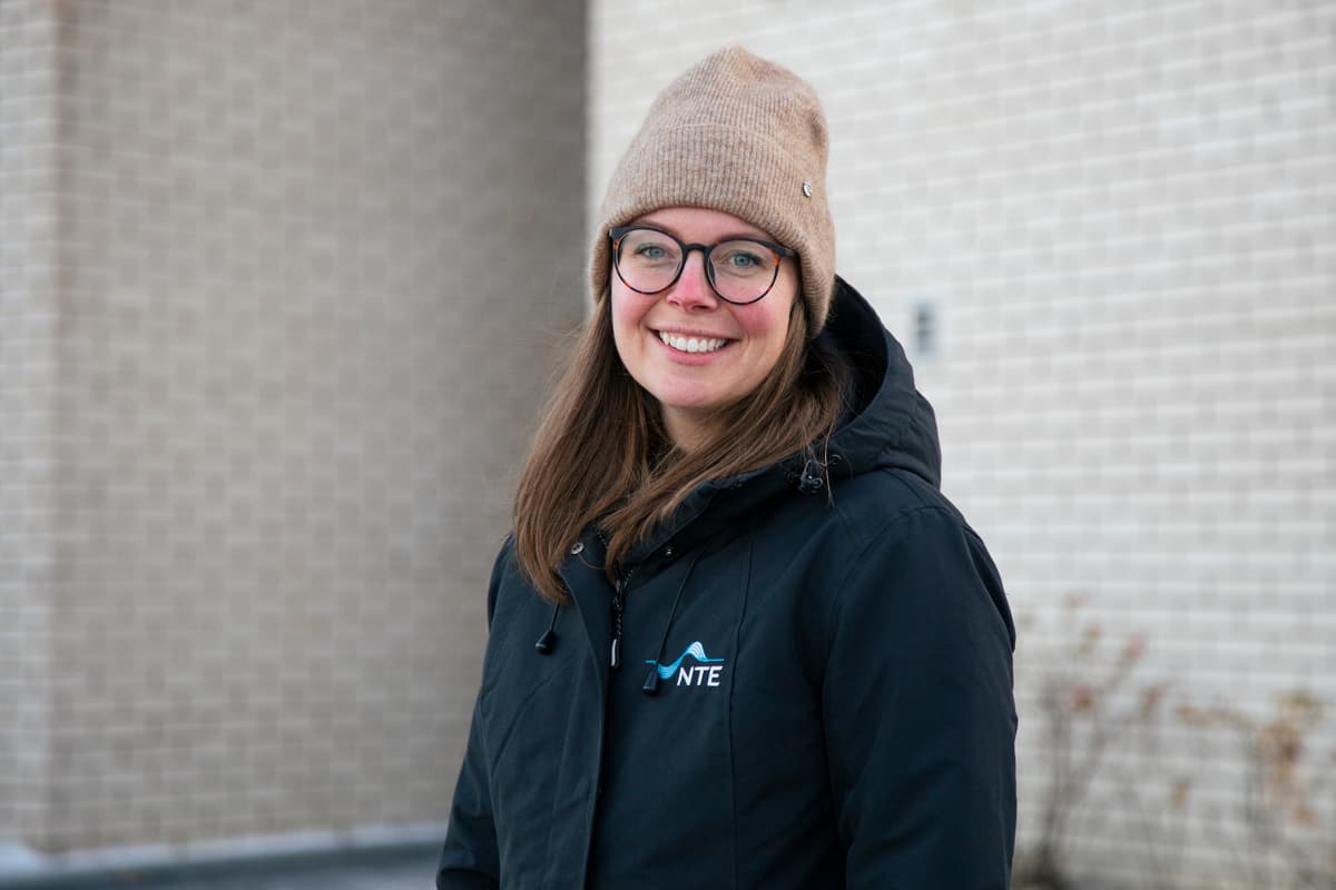 Marianne Rannem Veie Smilende dame med briller, lue og en vinterjakke med NTE-logoen på