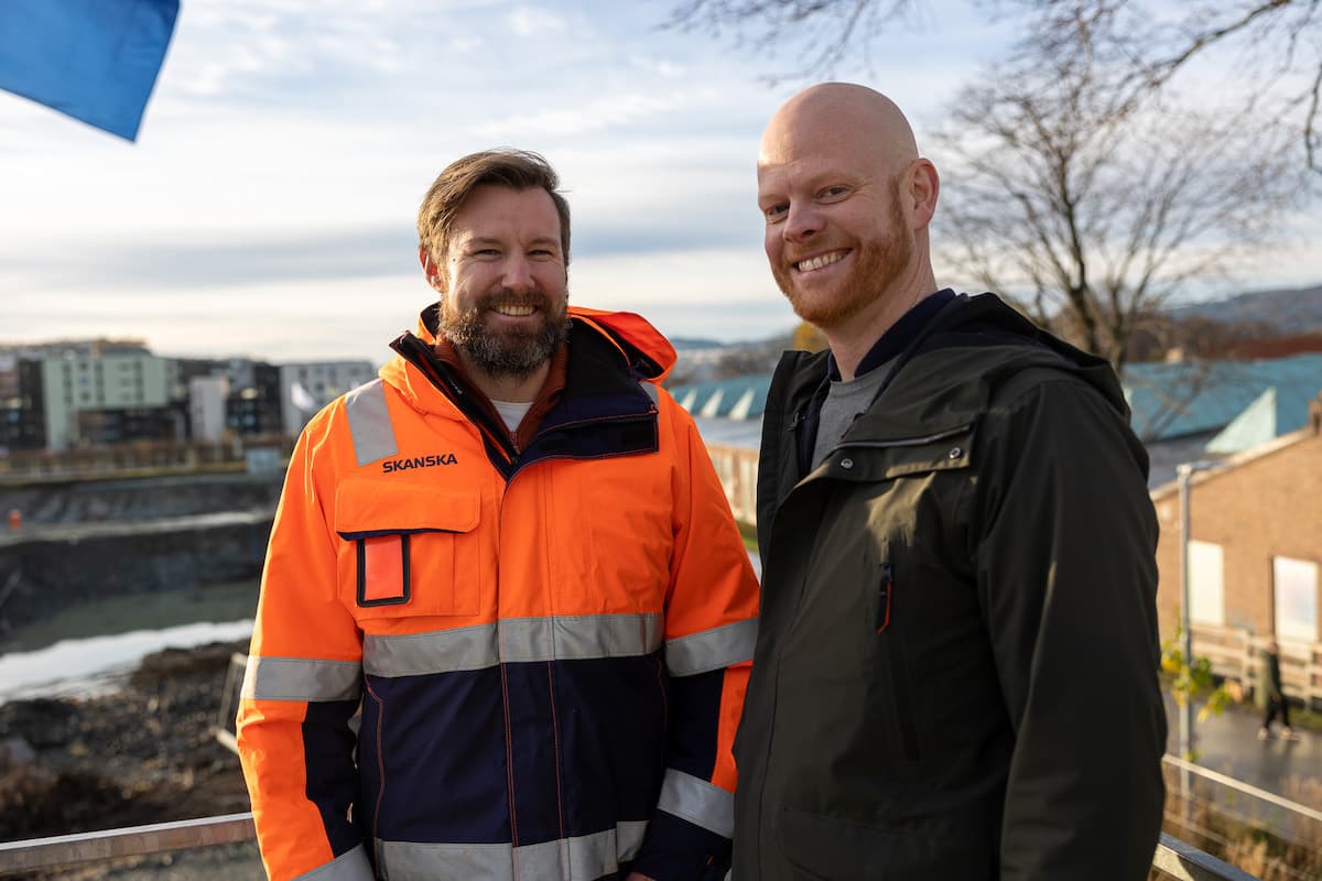 Kim Bundgård i Skanska og Frode Walstad To smilende menn foran en byggeplass