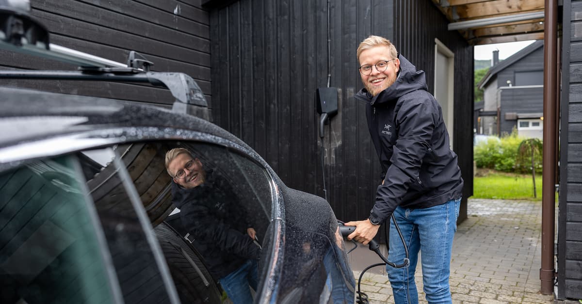 Petter Krohn-Hansen Smilende mann plugger laderen i elbilen sin
